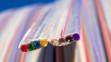 Ein Leerrohr für Lichtleiterkabel wird für die Verlegung vorbeiretet. Foto: Jens Büttner/zb/dpa/Symbolbild