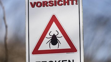 Ein Schild warnt vor Zecken. Foto: Patrick Seeger/dpa/Archivbild