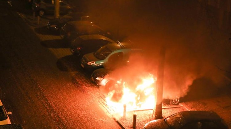 Ein Pkw brennt in einer Nebenstraße zwischen weiteren geparkten Autos. Foto: Jan Woitas/dpa-Zentralbild/dpa