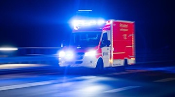 Ein Rettungswagen der Feuerwehr fährt mit Blaulicht durch eine Straße. Foto: Marcel Kusch/dpa/Symbolbild