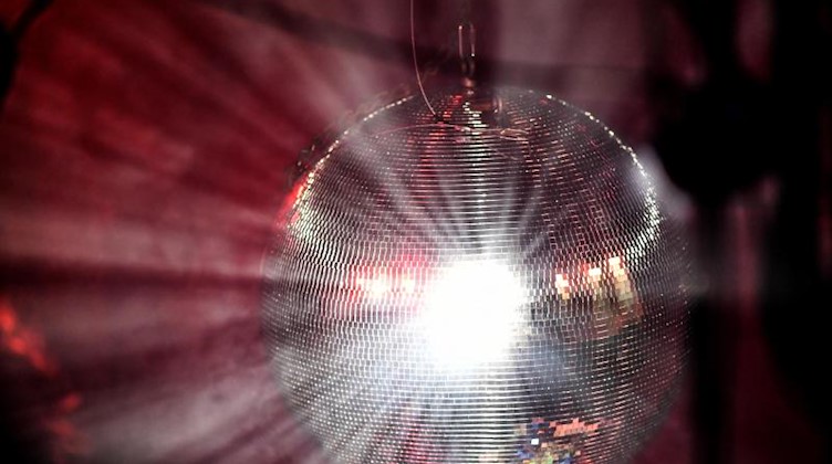 Eine Diskokugel reflektiert das einfallende Licht der Scheinwerfer und Lampen. Foto: Britta Pedersen/dpa-Zentralbild/dpa