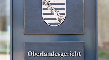 Ein Hinweisschild am Eingang zum Oberlandesgericht in Dresden. Foto: Robert Michael/zb/dpa/Archivbild