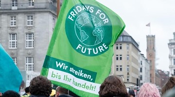 Das Logo von Fridays for Future ist während einer Demonstration auf einer Flagge zu sehen. Foto: Markus Scholz/dpa/Symbolbild