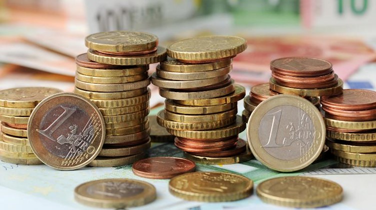 Euro-Münzen auf Euro-Banknoten. Foto: Tobias Hase/dpa/Symbolbild