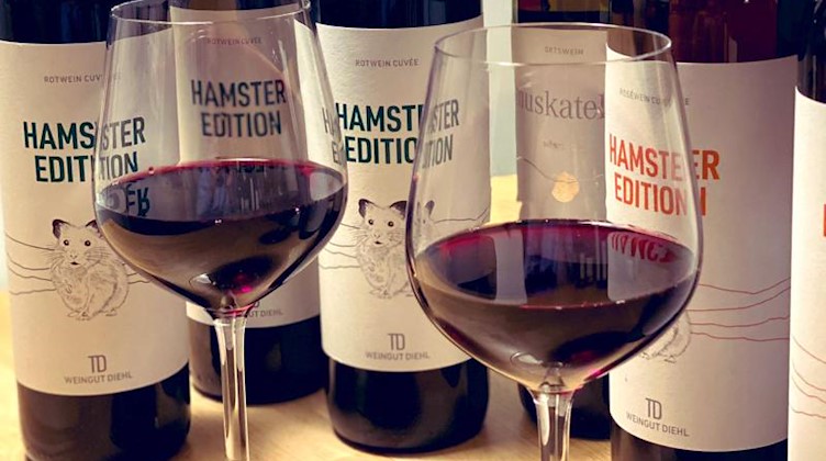 Weingläser und Flaschen der «Hamster Edition» stehen beim Weingut Diehl. Foto: Weingut Diehl/dpa/Archivbild