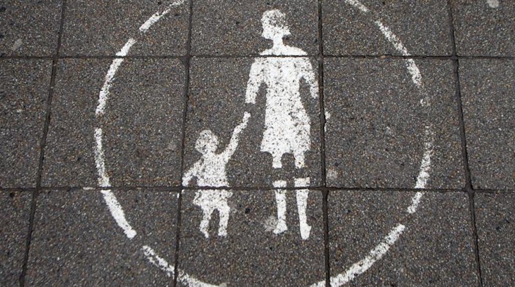 Ein Symbol einer Mutter mit einem Kind weist auf eine Fußgängerzone hin. Foto: picture alliance / dpa/Symbolbild