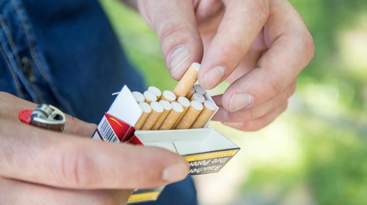 Ein Mann nimmt eine Zigarette aus einer Zigarettenschachtel. Foto: Christin Klose/dpa-tmn/Symbolbild