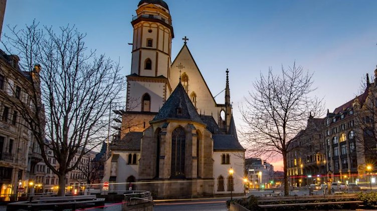 Abendrot leuchtet hinter der Thomaskirche in Leipzig. Foto: Hendrik Schmidt/dpa-Zentralbild/ZB/Archivbild