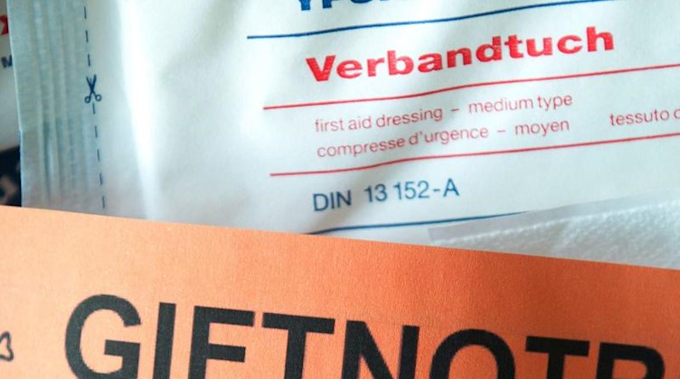 Ein Blatt mit der Giftnotrufnummer des Giftinformationszentrums liegt in einem Verbandskasten. Foto: Sebastian Kahnert/dpa-Zentralbild/dpa/Symbolbild