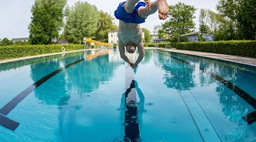 Ein Mann springt mit einem Kopfsprung in das Schwimmbecken im Schreberbad. Foto: Lukas Schulze/dpa-Zentralbild-Zentralbild/dpa/Archivbild