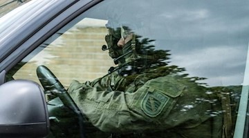 Polizisten fahren in einer Kolonne aus dem Innenhof des Justizzentrums Dresden. Foto: Robert Michael/dpa-Zentralbild/dpa/Archivbild