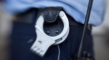 Handschellen hängen am Gürtel eines Justizbeamten. Foto: Friso Gentsch/dpa/Symbolbild
