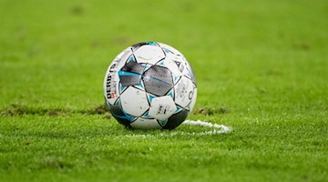 Ein Fußball liegt auf dem Rasen. Foto: Matthias Balk/dpa/Symbolbild