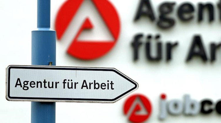 Ein Schild weist den Weg zur Agentur für Arbeit. Foto: Jan Woitas/dpa-Zentralbild/dpa/Archivbild