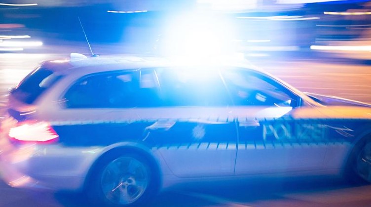 Ein Polizeiauto fährt unter Einsatz von Blaulicht und Sirene eine Straße entlang. Foto: Lino Mirgeler/dpa/Symbolbild