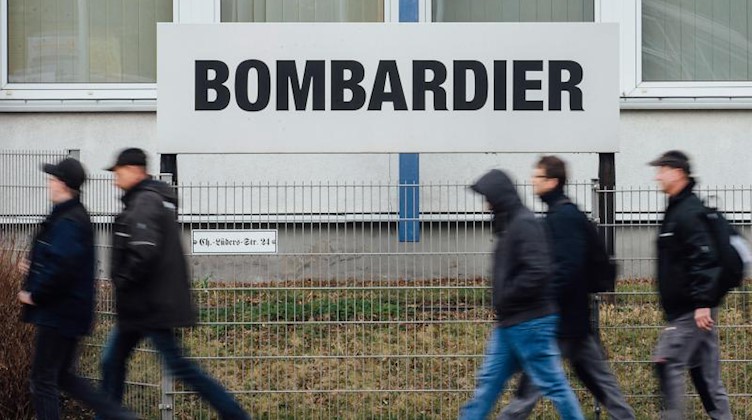 Mitarbeiter gehen am Werk von Bombardier vorbei. Foto: Oliver Killig/dpa-Zentralbild/dpa