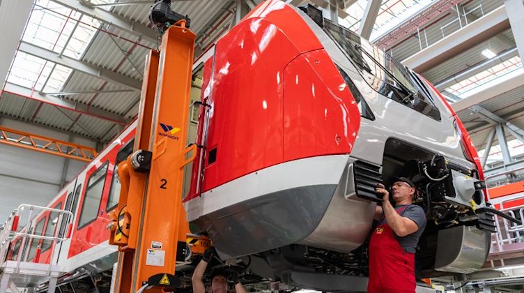 Mitarbeiter im Bombardier Werk montieren einen Waggon für eine S-Bahn. Foto: Robert Michael/dpa-Zentralbild/dpa/Archivbild