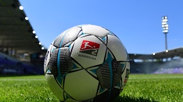 Ein Spielball liegt auf dem Rasen. Foto: Robert Michael/dpa-Zentralbild - Pool/dpa/Archivbild