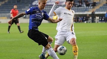 Bielefelds Nils Seufert und Dresdens Jannis Nikolaou (l-r.) im Zweikampf um den Ball. Foto: Friso Gentsch/dpa-pool/dpa