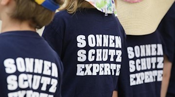 Schülerinnen und Schüler einer Dresdner Grundschule tragen beim Start eines bundesweiten Sonnenschutzprojektes T-Shirts mit der Aufschrift "Sonnenschutzexperte". Foto: Robert Michael/dpa-Zentralbild/dpa