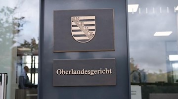 Justizbeamte stehen im Eingangsbereich des Prozessgebäude des Oberlandesgerichts Dresden. Foto: Sebastian Kahnert/dpa-Zentralbild/dpa/Archivbild