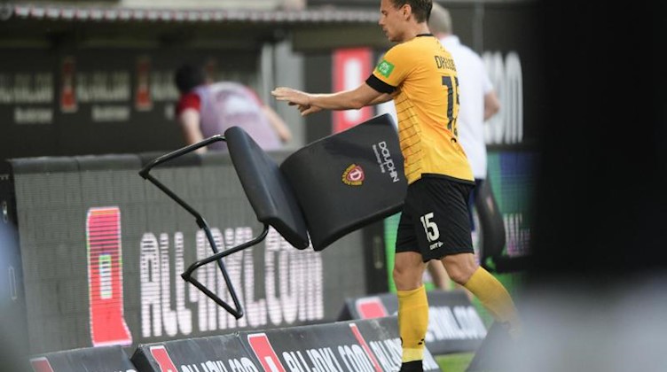 Dynamos Chris Löwe wirft nach der 0:1-Niederlage gegen Hamburg einen Stuhl weg. Foto: Robert Michael/dpa-Zentralbild/dpa/Archivbild