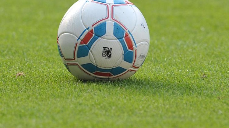 Ein Fußball liegt auf einem Spielfeld. Foto: picture alliance / dpa/Symbolbild