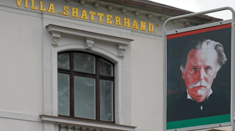 Ein Porträt des Schriftstellers Karl May hängt vor seinem einstigen Wohnhaus und jetzigem Museum. Foto: Matthias Hiekel/dpa-Zentralbild/dpa/Archivbild