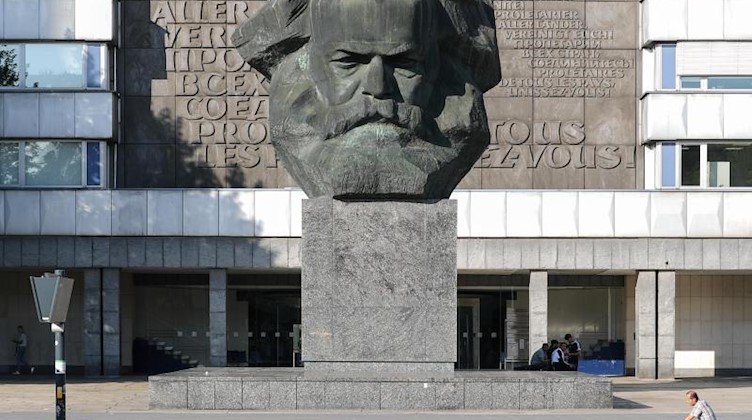 Ein Mann fährt vor dem Karl-Marx-Denkmal entlang. Foto: Jan Woitas/zb/dpa/Archivbild