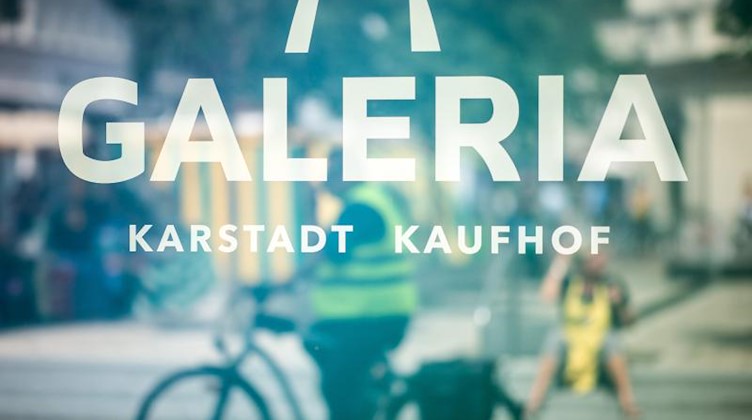 Menschen spiegeln sich in einem Schaufenster einer Galeria Karstadt Kaufhof Filiale. Foto: Jonas Güttler/dpa/Symbolbild