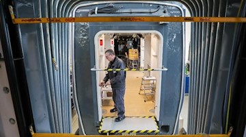 Ein Mitarbeiter arbeitet an einer Straßenbahn für die Hannoversche Üstra. Foto: Jan Woitas/dpa-Zentralbild/dpa/Symbolbild