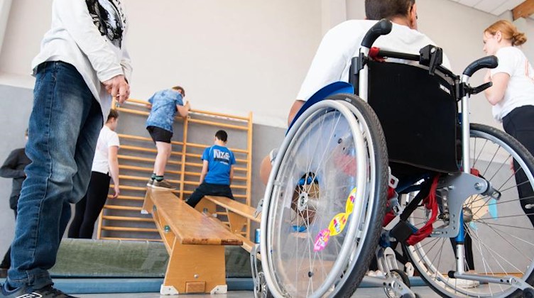 Ein Schüler im Rollstuhl nimmt am Sportunterricht teil. Foto: Julian Stratenschulte/dpa/Symbolbild