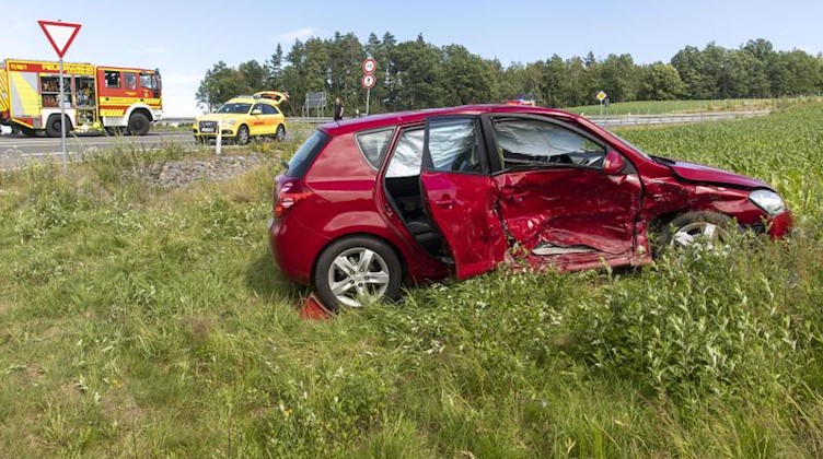 Ein stark beschädigtes Auto steht nach einem Zusammenstoß mit einem anderen Auto auf einer Wiese. Foto: Bernd März/dpa