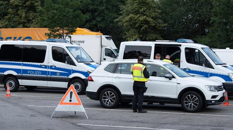 Polizisten stehen während eines Kontrolleinsatzes der Polizeidirektion Görlitz auf dem Autobahn-Parkplatz «Löbauer Wasser». Foto: Sebastian Kahnert/dpa-Zentralbild/dpa