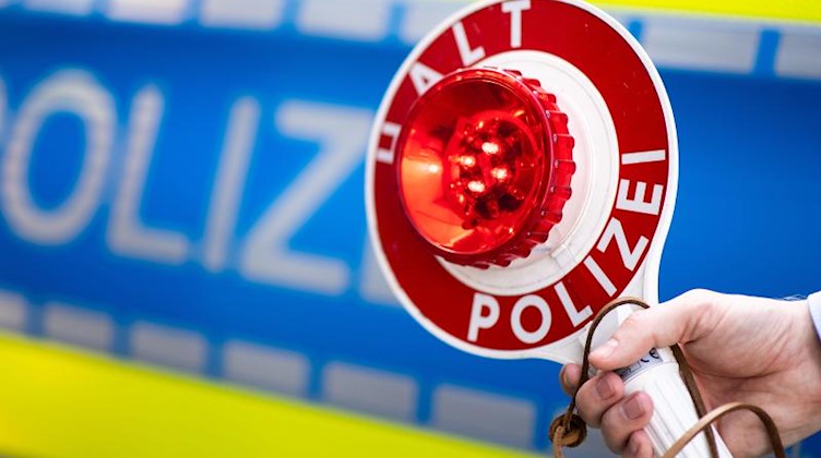 Ein Polizist bittet um Anhalten. Foto: Marius Becker/dpa/Symbolbild