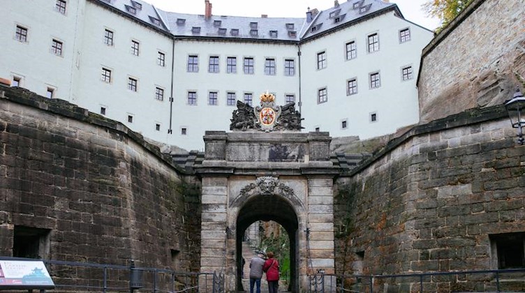 Besucher gehen durch das Medusentor vor der Festung Königstein. Foto: Oliver Killig/dpa-Zentralbild/dpa/Archivbild