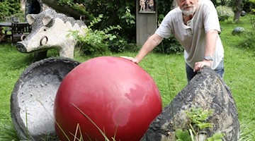Franz Poppe, Keramiker und Kunsthandwerker, steht in seinem Skulpturengarten. Foto: Bernd Wüstneck/dpa-Zentralbild/dpa