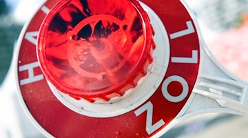 Ein Mann hält eine Winkerkelle mit der Aufschrift «Halt Zoll». Foto: picture alliance/Christophe Gateau/dpa/Archiv/Illustration