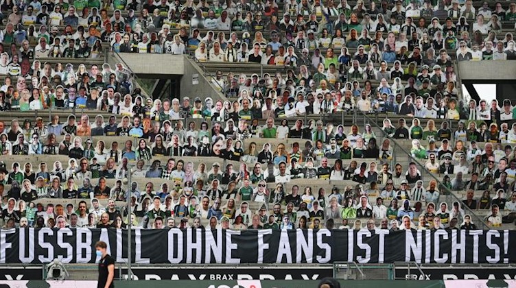 Fußball: Bundesliga, Bor. Mönchengladbach - VfL Wolfsburg, 32. Spieltag im Stadion im Borussia-Park. Pappaufsteller stehen statt der Fans auf der Tribüne, an der ein Banner mit der Aufschrift «Fussball ohne Fans ist nichts!» hängt. (zu dpa «Bundesliga-Clubs stimmen ab: Zündstoff bei Fan-Rückkehr in Stadien »). Foto: Federico Gambarini/dpa-Pool/dpa/archiv