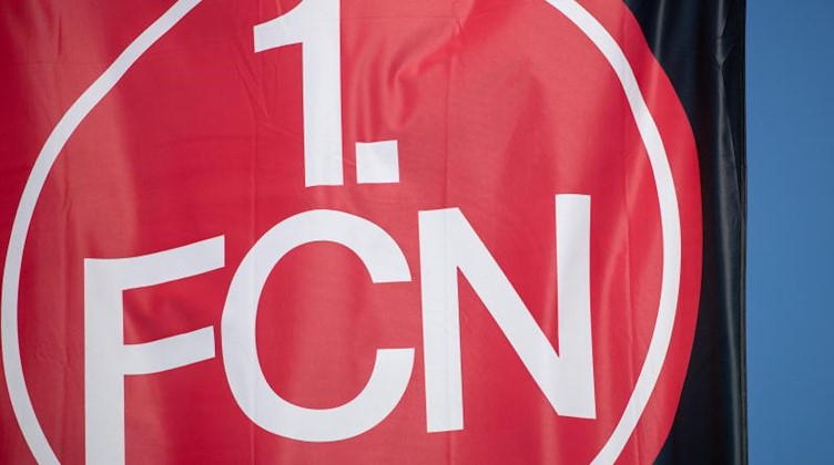 Eine Vereinsfahnen mit dem Logo des 1. FC Nürnberg. Foto: Daniel Karmann/dpa/Archivbild