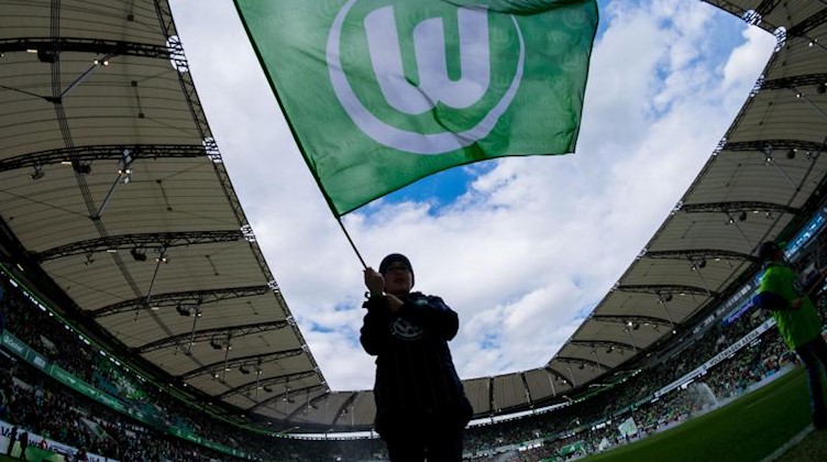 Ein Mensch mit einer VfL-Fahne. Foto: picture alliance/Peter Steffen/dpa/Archivbild