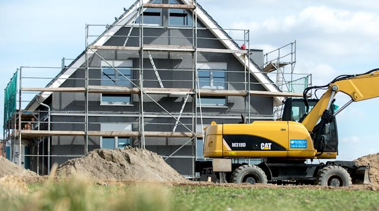 Ein eingerüsteter Rohbau eines Einfamilienhauses steht in einem Neubaugebiet. Foto: Hauke-Christian Dittrich/dpa/Symbolbild