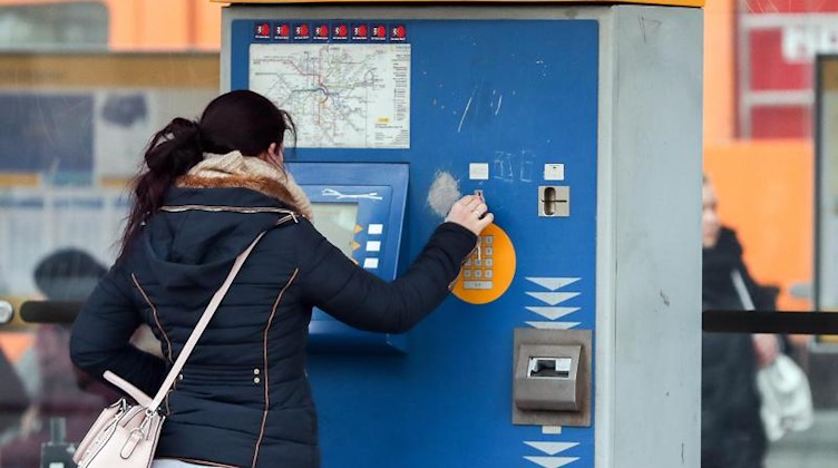 Eine Frau kauft an einem MDV-Automaten eine Fahrkarte. Foto: Jan Woitas/dpa-Zentralbild/ZB/Symbolbild