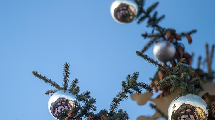 Das Rathaus und die Buden des Weihnachtsmarktes spiegeln sich Kugeln am Weihnachtsbaum. Foto: Klaus-Dietmar Gabbert/dpa-Zentralbild/ZB/Archiv