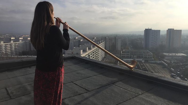 Die Alphornistin Anna Katharina Schumann probt für das Konzert «Himmel über Prohlis». Foto: --/Dresdner Sinfoniker/Therese Menzel/dpa/Archivbild