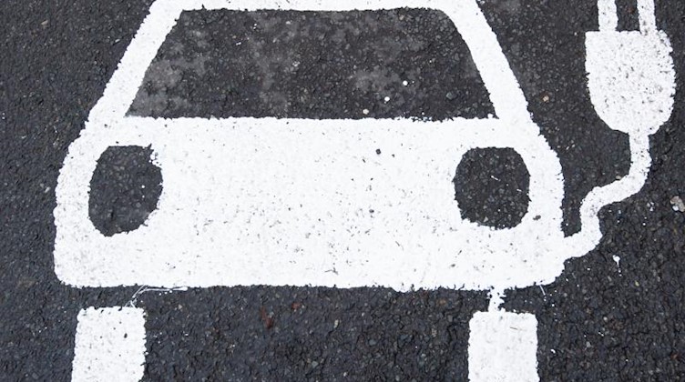 Ein Symbol für ein Elektroauto markiert einen Parkplatz neben einer E-Ladesäule. Foto: Julian Stratenschulte/dpa/Archivbild
