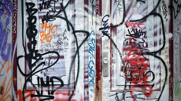 Eine mit Graffiti besprühte Eingangstür. Foto: Britta Pedersen/dpa-Zentralbild/dpa