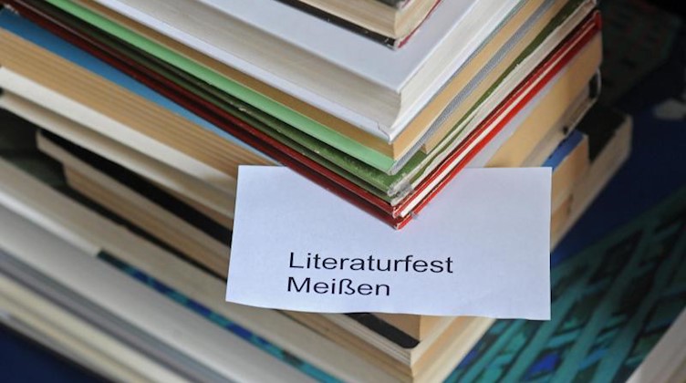 Ein Bücherstapel und ein Merkzettel mit der Aufschrift «Literaturfest Meißen» ist zu sehen. Foto: Matthias Hiekel/dpa-Zentralbild/dpa/Symbolbild