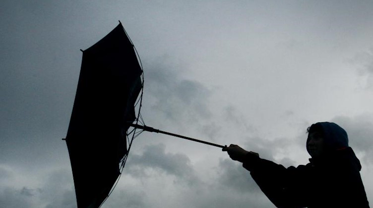 Ein Regenschirm eines Spaziergängers wird von einer Windböe erfasst. Foto: picture alliance / Karl-Josef Hildenbrand/dpa/Symbolbild
