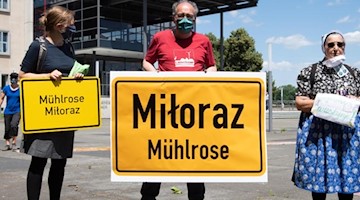 Umweltschützer stehen vor dem Landtag von Sachsen, um gegen das Abbaggern weiterer Dörfer für die Braunkohleförderung zu demonstrieren. Foto: Sebastian Kahnert/dpa-Zentralbild/dpa